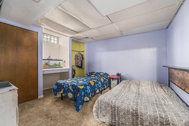 carpeted bedroom with a paneled ceiling