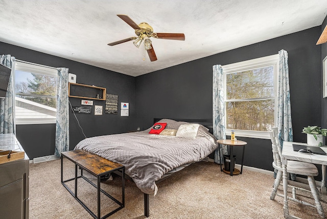 carpeted bedroom featuring a ceiling fan, baseboards, and a textured ceiling