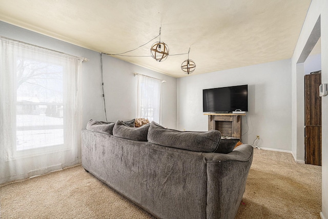 living room featuring plenty of natural light, a fireplace, and light colored carpet