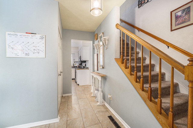 interior space with light tile patterned floors, baseboards, stairway, and visible vents