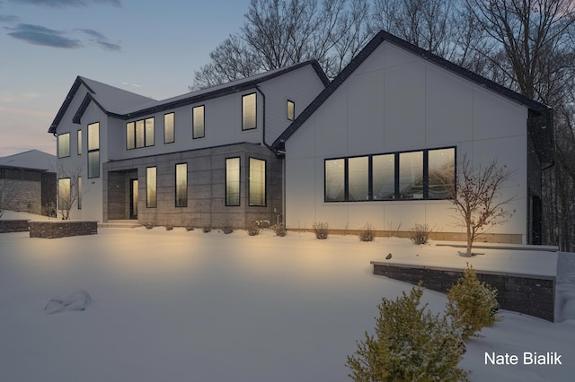 view of snow covered back of property