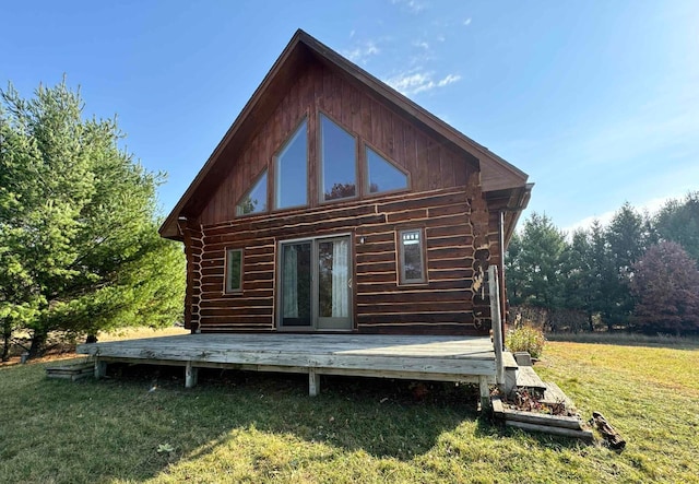 back of house with a wooden deck, log exterior, and a yard