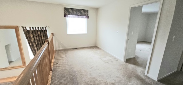 carpeted spare room featuring baseboards