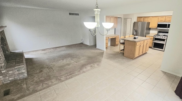 kitchen featuring light colored carpet, a kitchen island, visible vents, light countertops, and appliances with stainless steel finishes