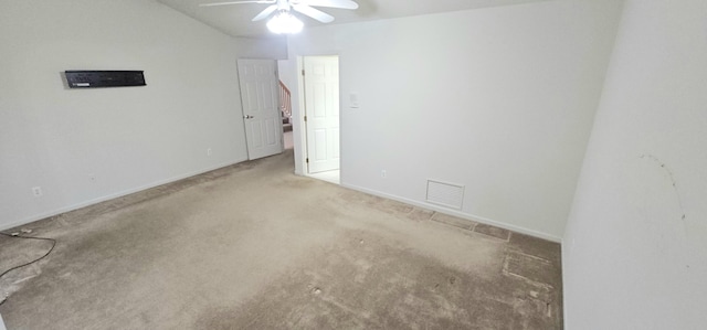 carpeted spare room with a ceiling fan, visible vents, and baseboards