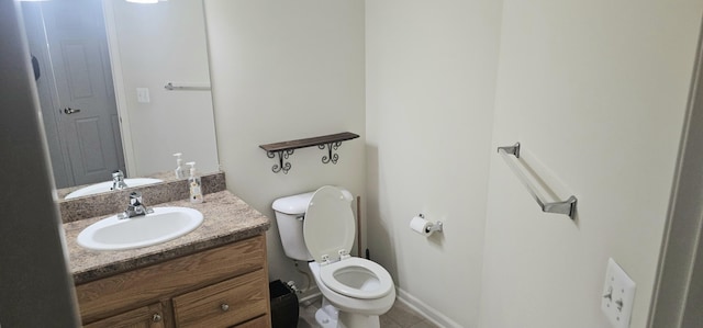 half bathroom with toilet, vanity, and baseboards