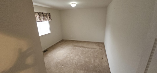 unfurnished room featuring carpet floors and baseboards
