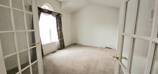 carpeted spare room with lofted ceiling and plenty of natural light