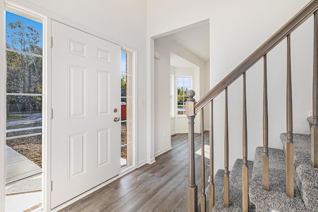 foyer featuring stairs, dark wood-style flooring, and baseboards