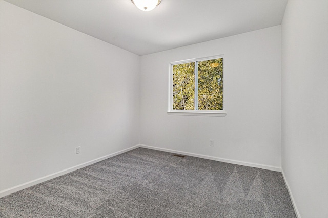 carpeted spare room featuring baseboards