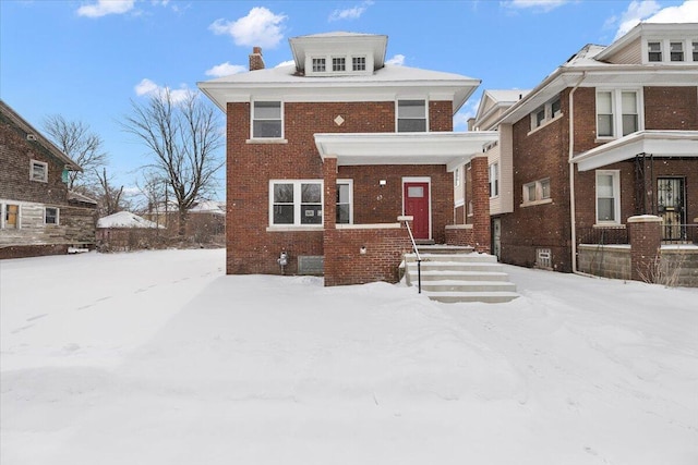 american foursquare style home with brick siding and a chimney