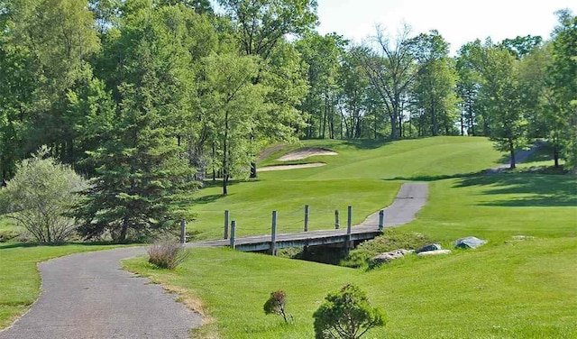 surrounding community with a yard and golf course view
