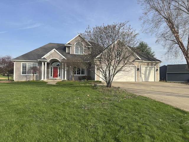 traditional home with an attached garage, driveway, and a front yard