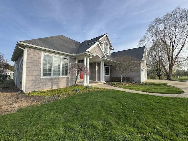 view of front of house featuring a garage, covered porch, a front yard, roof with shingles, and driveway