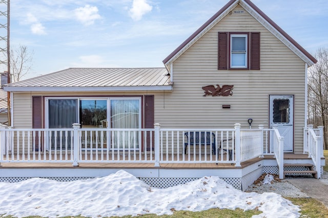 view of front of property featuring metal roof and a wooden deck