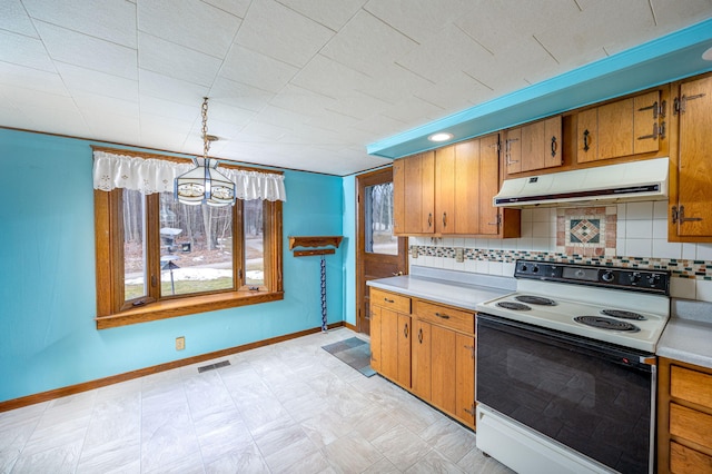 kitchen featuring white range with electric stovetop, visible vents, brown cabinets, light countertops, and under cabinet range hood