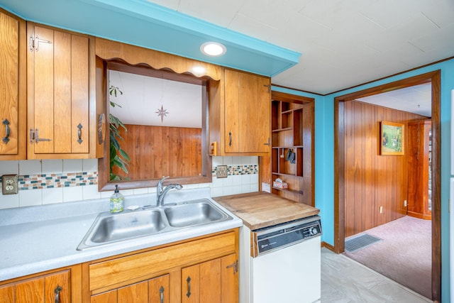 kitchen featuring dishwasher, light countertops, a sink, and visible vents