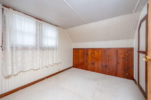 bonus room featuring lofted ceiling, wallpapered walls, carpet, and baseboards