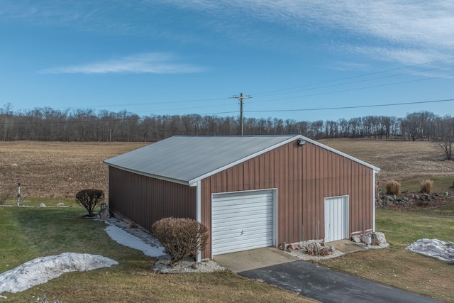 view of outdoor structure with aphalt driveway and an outbuilding