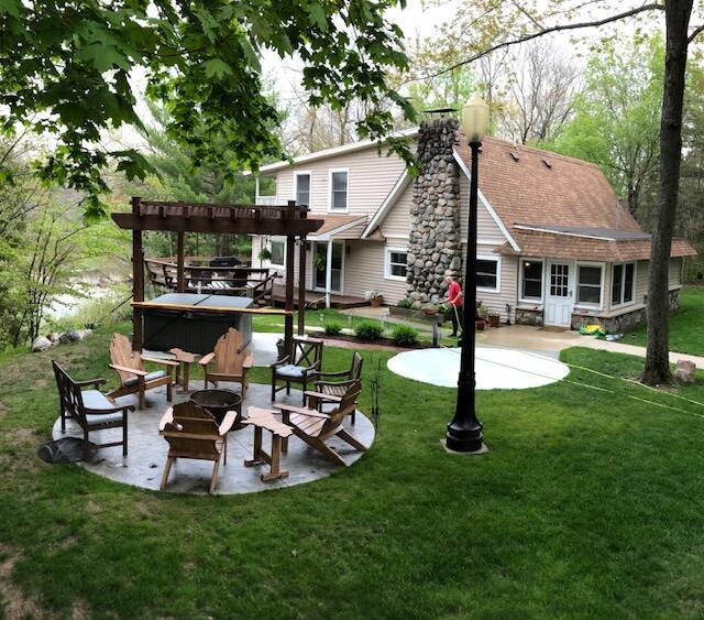 back of house featuring a patio area, a lawn, a fire pit, and a pergola