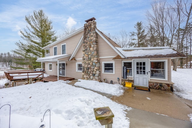 view of front of home featuring a chimney and a wooden deck