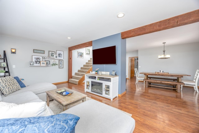 living area with light wood-type flooring, baseboards, recessed lighting, and stairs