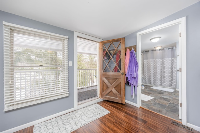 doorway with visible vents, baseboards, and wood finished floors