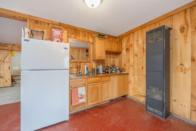 kitchen featuring freestanding refrigerator, a heating unit, a sink, and wooden walls