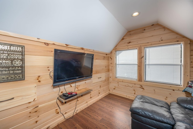 living room with wood walls, vaulted ceiling, wood finished floors, and recessed lighting