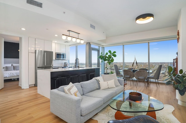 living area featuring light wood-style floors, visible vents, and recessed lighting