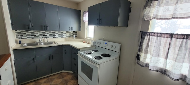 kitchen featuring backsplash, white electric stove, light countertops, and a sink