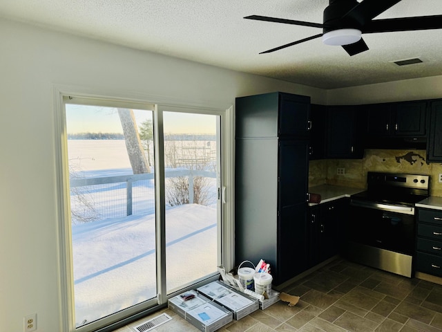 kitchen featuring electric range, visible vents, light countertops, and dark cabinets