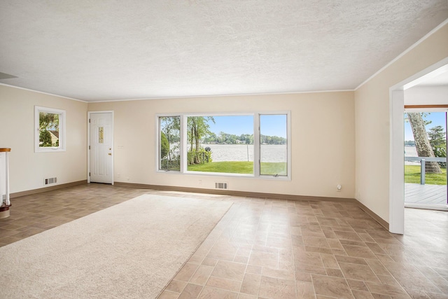 unfurnished living room featuring baseboards, visible vents, and a healthy amount of sunlight