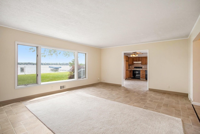 empty room with a water view, visible vents, baseboards, and a textured ceiling