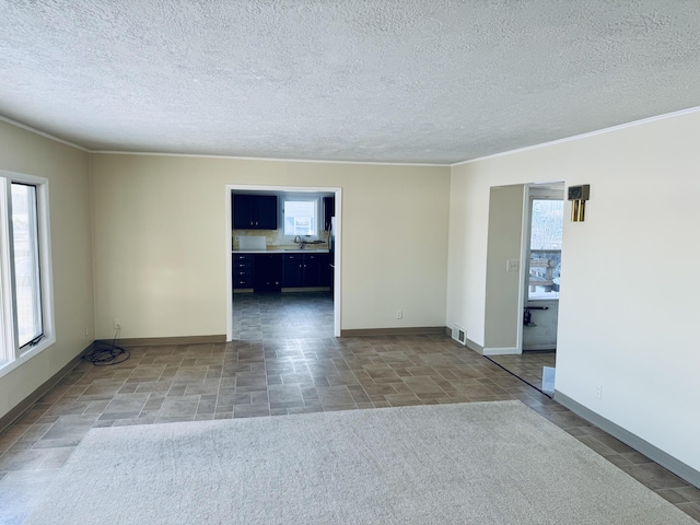 spare room with plenty of natural light, visible vents, baseboards, and a sink