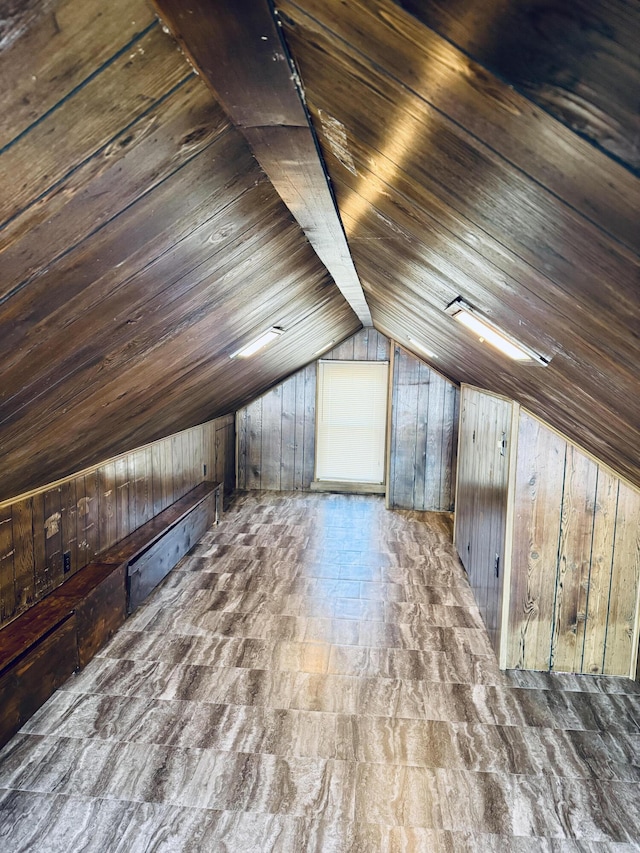 additional living space with vaulted ceiling, wood ceiling, and wooden walls