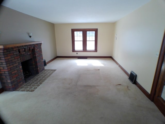 unfurnished living room featuring baseboards, a brick fireplace, visible vents, and light colored carpet