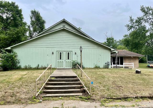 rear view of property featuring a lawn