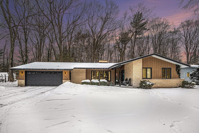 mid-century modern home featuring an attached garage and brick siding