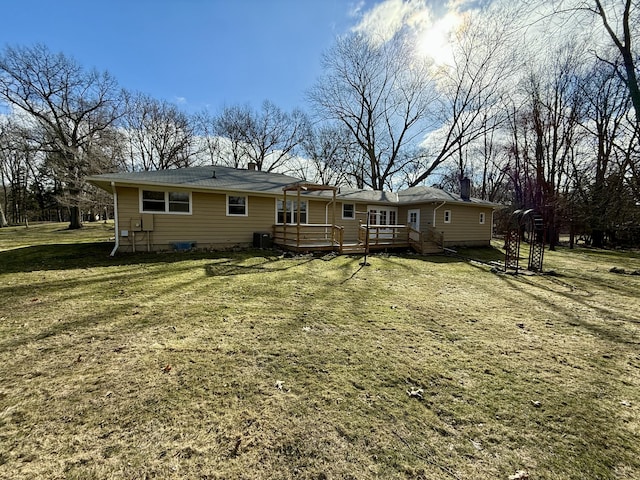 back of house with central AC unit, a deck, and a yard