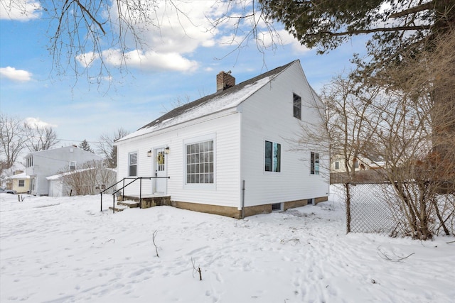 snow covered property with a chimney