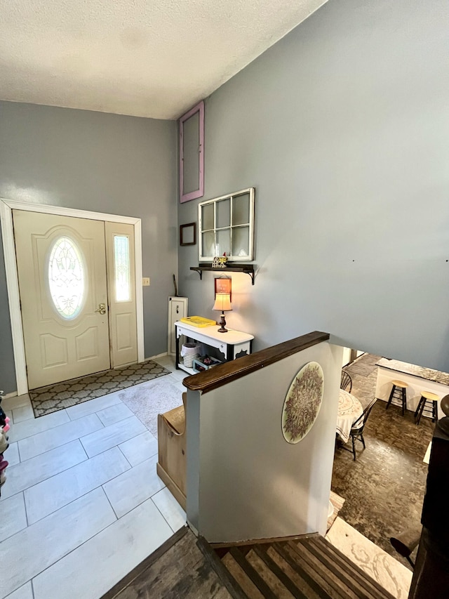 foyer with vaulted ceiling and a textured ceiling