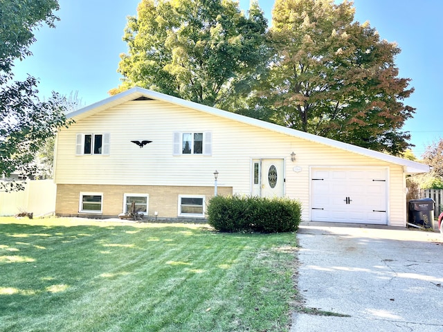 tri-level home with a garage, driveway, and a front lawn