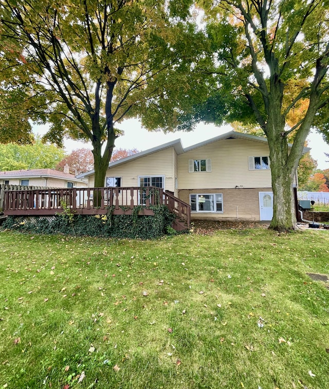 back of house with a lawn and a wooden deck