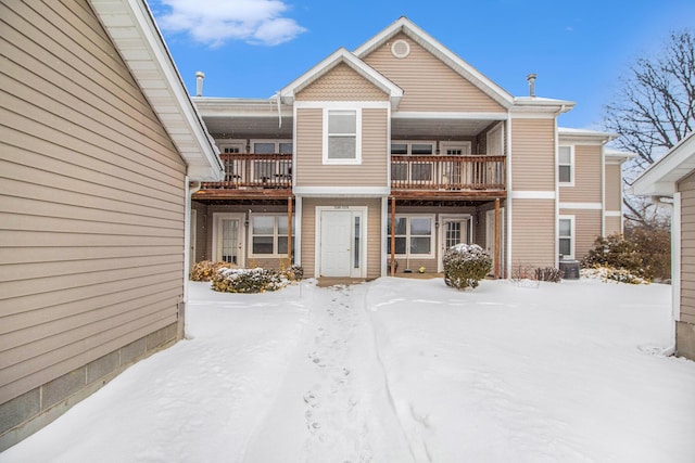 snow covered property featuring a balcony and central air condition unit