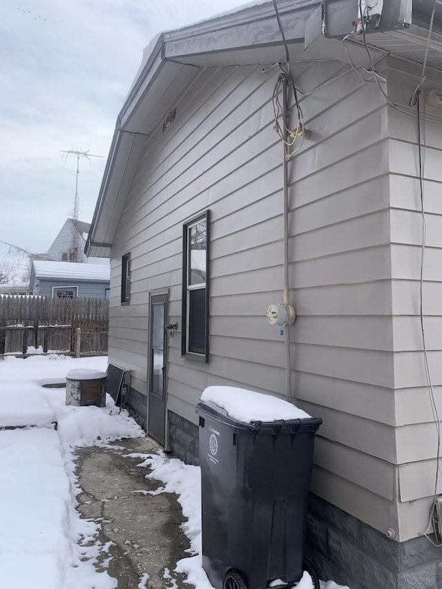 view of snowy exterior with fence