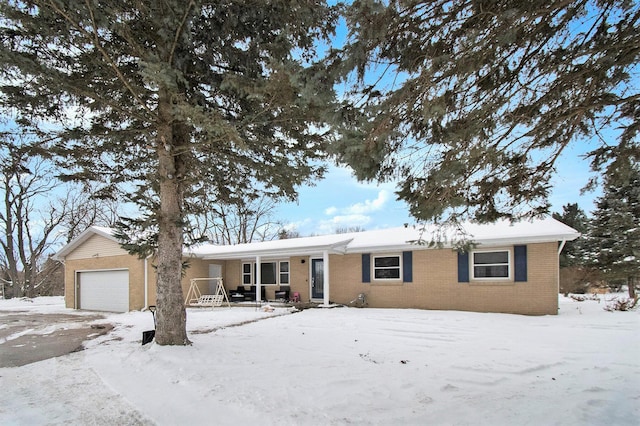 ranch-style home with covered porch, brick siding, and an attached garage