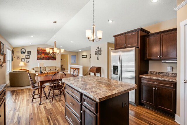 4588 Gordonshire NW, Grand Rapids, MI 49534 - kitchen with a center island, vaulted ceiling, light wood finished floors, a notable chandelier, and stainless steel fridge