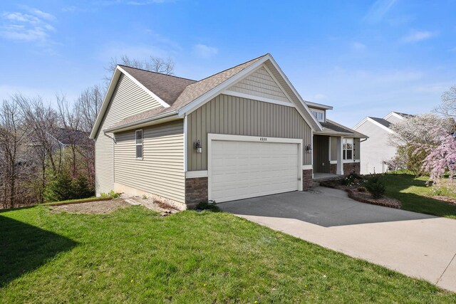 4588 Gordonshire NW, Grand Rapids, MI 49534 - view of side of property with roof with shingles, an attached garage, a yard, and aphalt driveway