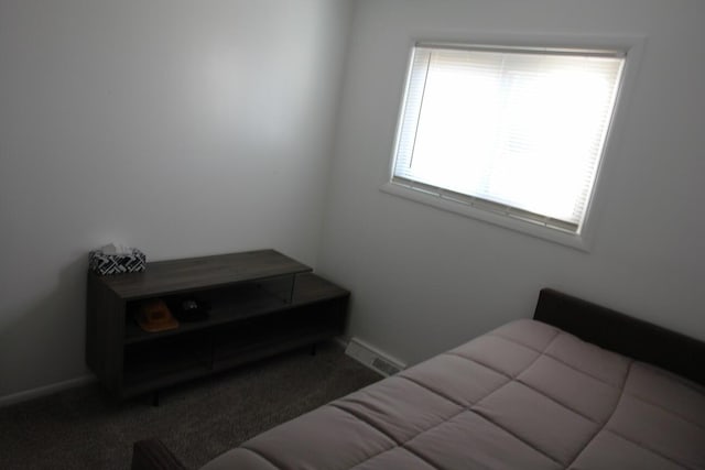 bedroom featuring dark colored carpet, visible vents, and baseboards